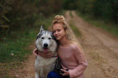 İri yapılı bir kız ormanda yürüyor..