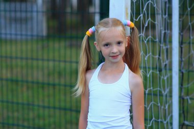 Spor sahasında futbol kalesine yakın poz veren bir kız..