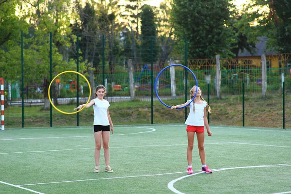 Dos niñas entrar para los deportes en el patio de recreo —  Fotos de Stock