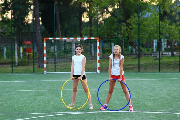 Дві дівчини займаються спортом на дитячому майданчику — стокове фото
