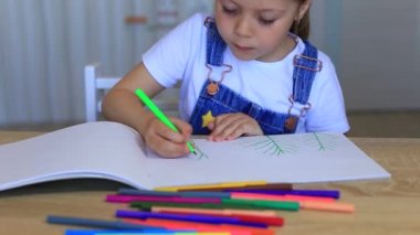 Çocuk ev yalıtımında renkli kalemlerle kağıda resim çiziyor..