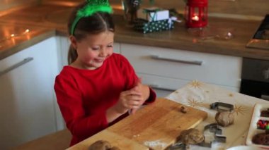 Mutlu küçük kız Noel arifesinde kurabiye hazırlar..