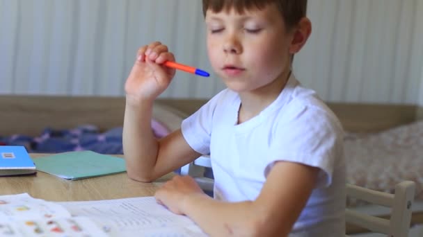 Un enfant fait ses devoirs sur l'isolement. Travail à domicile. — Video