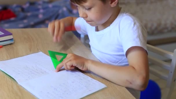 Un enfant fait ses devoirs sur l'isolement. Travail à domicile. — Video