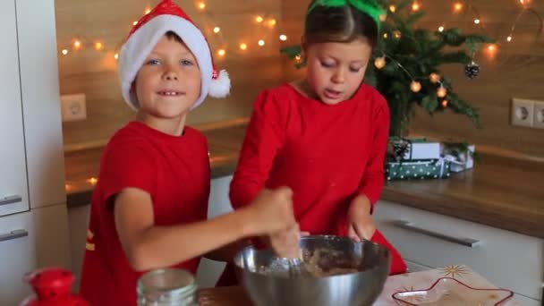 Glada barn förbereder pepparkakor på kvällen till nyår. — Stockvideo