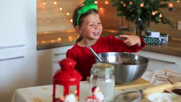Lycklig liten flicka förbereder kakor på kvällen till jul. — Stockvideo