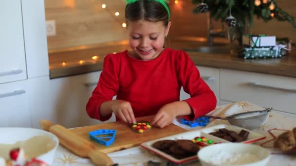 Lycklig liten flicka förbereder kakor på kvällen till jul. — Stockvideo