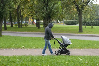 Genç baba bebek arabasını yuvarladı