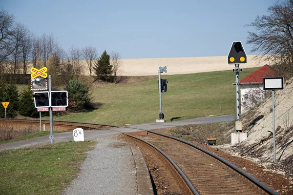 Korumasız demiryolu geçişi. Çek Cumhuriyeti'ndeki bir tren geçidinde demiryolu sinyalizasyon ekipmanları. Demiryolu altyapısı. Güneşli hava. — Stok fotoğraf