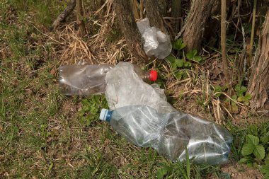 Yerdeki plastik kirliliği. Plastik atıklar yerde yatıyor. Çevre Koruma. Plastik şişeler ve diğer çöp ler yer.