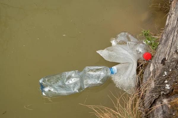 Vervuiling van kunststof in water. Plastic afval zweeft in water. Milieubescherming. Plastic flessen en andere vuilnis op het water. — Stockfoto