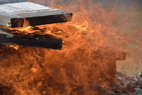 Spalanie drewnianych skrzyń wojskowych z amunicji. Tlący się kominek. Duży palący ogień. — Zdjęcie stockowe
