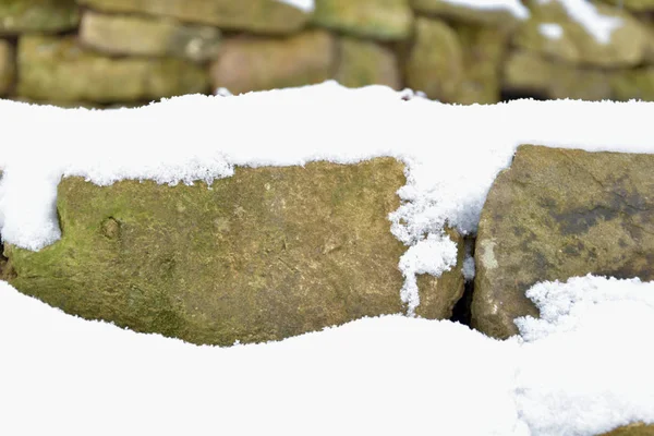 Karlı taş duvar. Karla kaplı taşlar. — Stok fotoğraf