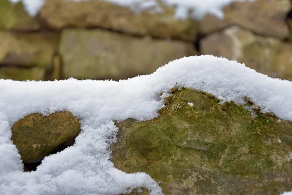 Snowy kamienny mur. Kamienie pokryte śniegiem. — Zdjęcie stockowe