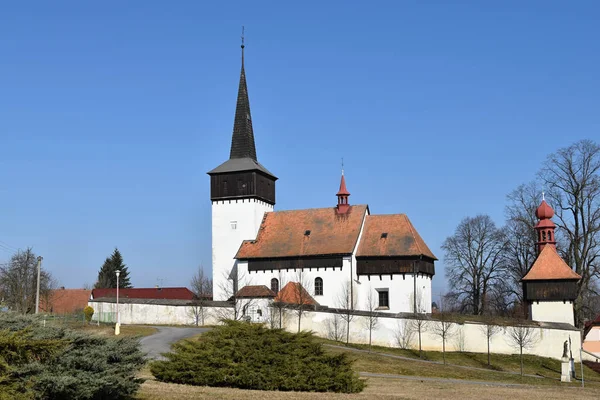 Catholic church, the cemetery wall. Blue sky.