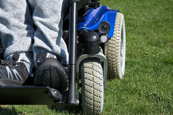 Electric wheelchair. Young man in a wheelchair on the grass