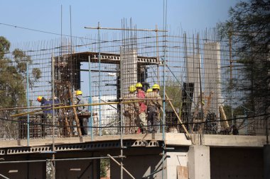 Construction workers with hard hats in a building under construction with iron structures