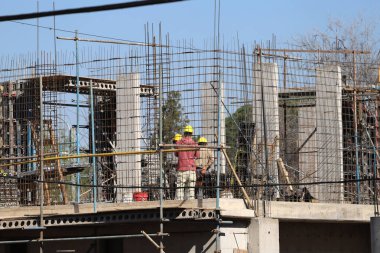 Bricklayers working on a building under construction. Real estate development concept, workers at work.