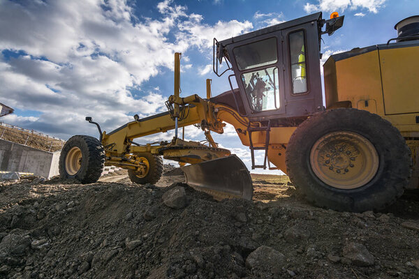 Motor grader at the construction site of a road
