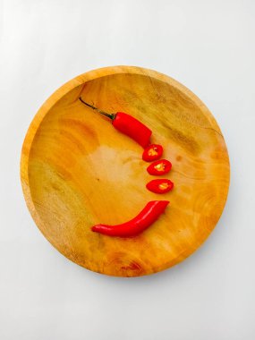 Kırmızıbiber seti parçalara ayrılmış, ahşap bir tabakta servis edilmiş, beyaz arka planda izole edilmiş..