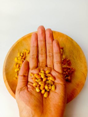 Tahta bir tabakta soya fasulyesi taşıyor, beyaz arka planda izole edilmiş..