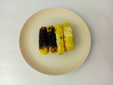 Tabağa çikolata parçacıklı ve peynirli Pukis kekleri, beyaz arka planda izole edilmiş buğday unu, yumurta, maya ve hindistan cevizi sütü karışımı geleneksel Endonezya yemekleri..