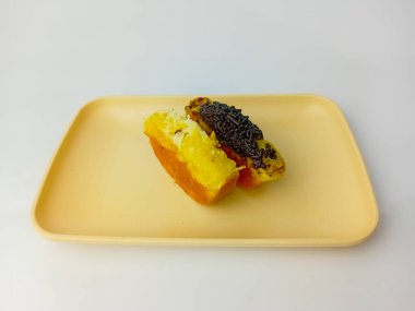 Tabağa çikolata parçacıklı ve peynirli Pukis kekleri, beyaz arka planda izole edilmiş buğday unu, yumurta, maya ve hindistan cevizi sütü karışımı geleneksel Endonezya yemekleri..