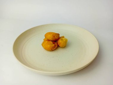 Molen pisang ya da muz meyveleri un örtüsüne sarılır ve kızartılır. Endonezya geleneksel çerezi. Tabakta servis edilir, beyaz arkaplanda izole edilir..