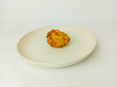 Beyaz arka planda izole edilmiş yuvarlak bir tabakta servis edilen Bala-Bala veya sebzeli börek.