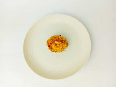 Beyaz arka planda izole edilmiş yuvarlak bir tabakta servis edilen Bala-Bala veya sebzeli börek.