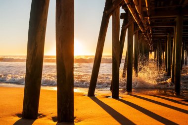 Atlantik kıyısında şafak. Eski bir ahşap iskele karşı çökmesini dalgalar. Amerika Birleşik Devletleri. Maine