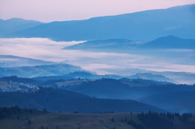 Engebeli dağ arazi üzerinde aşağı bak. Karanlık fotoğraf, gece gelen sis dağların doruklarına arasında dağlarda,.
