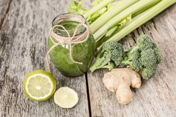 Smoothies yeşil sebze ve çevresinde çeşitli yeşil sebzeler üzerinde eski bir ahşap arka plan kırık. Vitaminler vücut detoks temizlik, kokteyl.