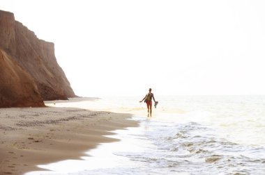 Adam vahşi bir kumsalda çalışıyor. sağlıklı bir yaşam tarzı, mutluluk ve kaygısız bir atmosfer. Seçici yumuşak odak.