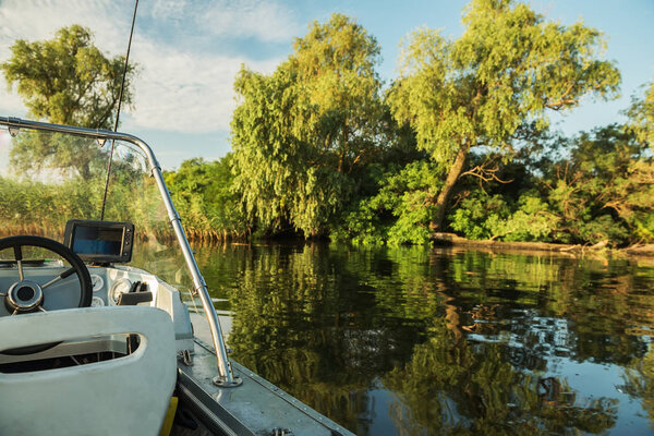 A fishing boat with an echosounder on a wild overgrown river.