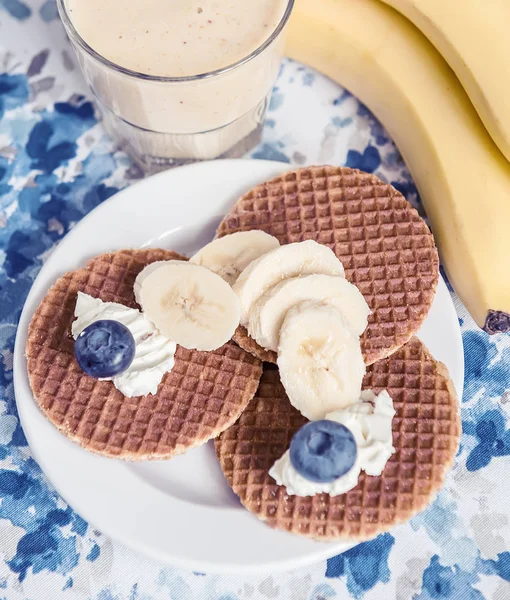Banana frash, waffles with soft cheese and many different berries. Useful tasty breakfast, snack.