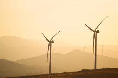 Güç jeneratörleri siluetleri dağ doruklarına arka plan üzerinde rüzgar. Sadelik ve minimal hatları. Doğanın gücünü güzel manzara.