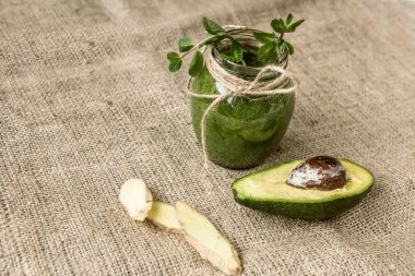 Yeşil smoothies sebze ve avokado kaba çuval bezi üzerinde yapılan.