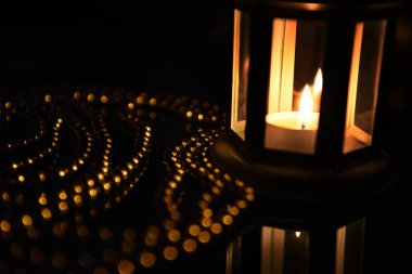 Bir mum parlak ve çok renkli bokeh arasında siyah zemin lambası.