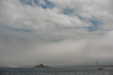 Okyanus ve bir yat yelken altında küçük bir ada. Minimalizm. Amerika Birleşik Devletleri. Maine.