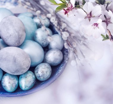 Geleneksel Paskalya yumurta ve çiçekler minal ağacının boyalı. Sanatsal kolaj. Seçici yumuşak odak.