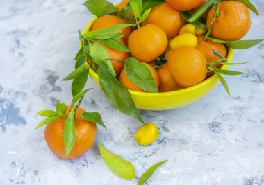 Mandalina hafif bir arka plan üzerinde yeşil yaprakları ile. Parlak iştah açıcı narenciye.