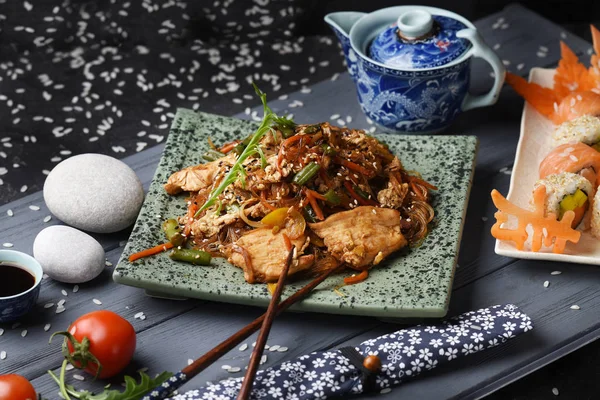 Dish with rice noodles with vegetables and chicken fillet. Thai, Chinese cuisine.