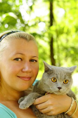 Bahçe onun kollarında bir gri oyuncak kedi kız.