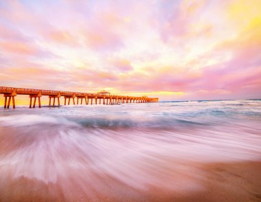 Atlantik Okyanusu kıyısında Pier gün batımında. Florida. Amerika Birleşik Devletleri. Uzun pozlama.