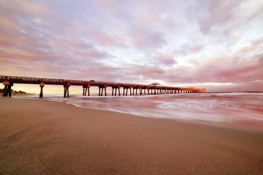 Atlantik Okyanusu kıyısında Pier gün batımında. Florida. Amerika Birleşik Devletleri. Uzun pozlama.