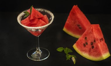Dilim karpuz siyah arka plan ve bir cam kadehi, yaz ruh hali.