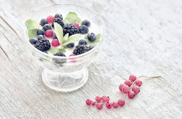 Summer light breakfast. Berries with yogurtmo and simple flowers. Vintage style.