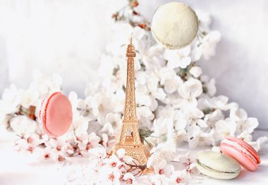 Beyaz kiraz çiçekleri ve tatlı çok renkli macaroons arasında Eyfel Kulesi heykelcik. Aşk, romantizm, bahar.