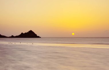 Cennet Adası beach.long pozlama üzerinde Hint Okyanusu üzerinde vahşi bir plajda gün batımı. Seçici yumuşak odak.